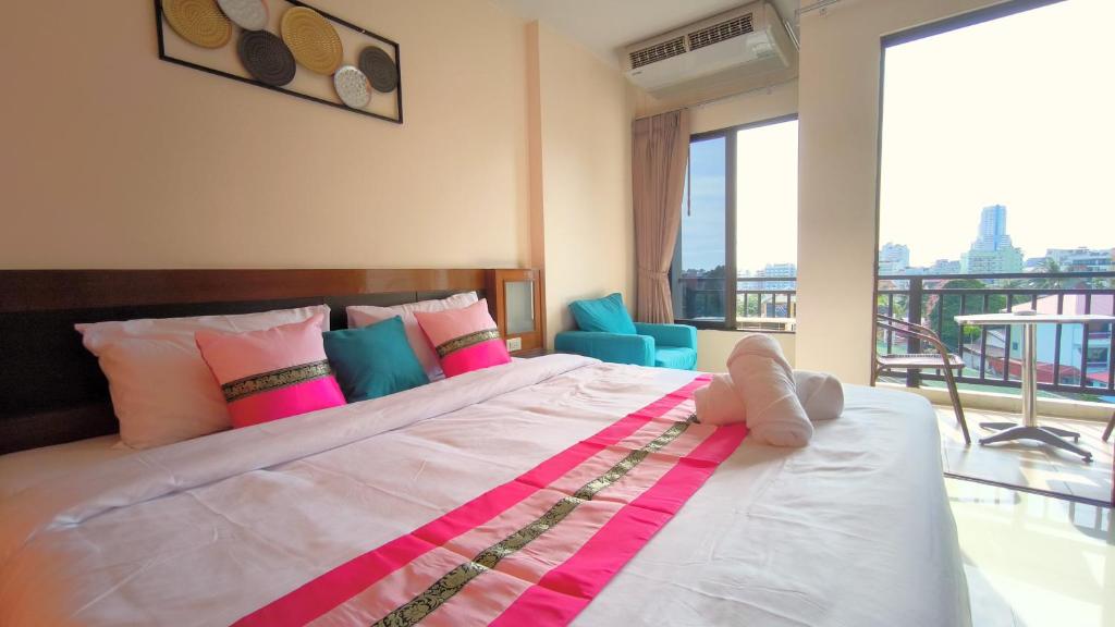 芭东海滩Lucky Buako Hotel Patong的一间带大床的卧室和一个阳台