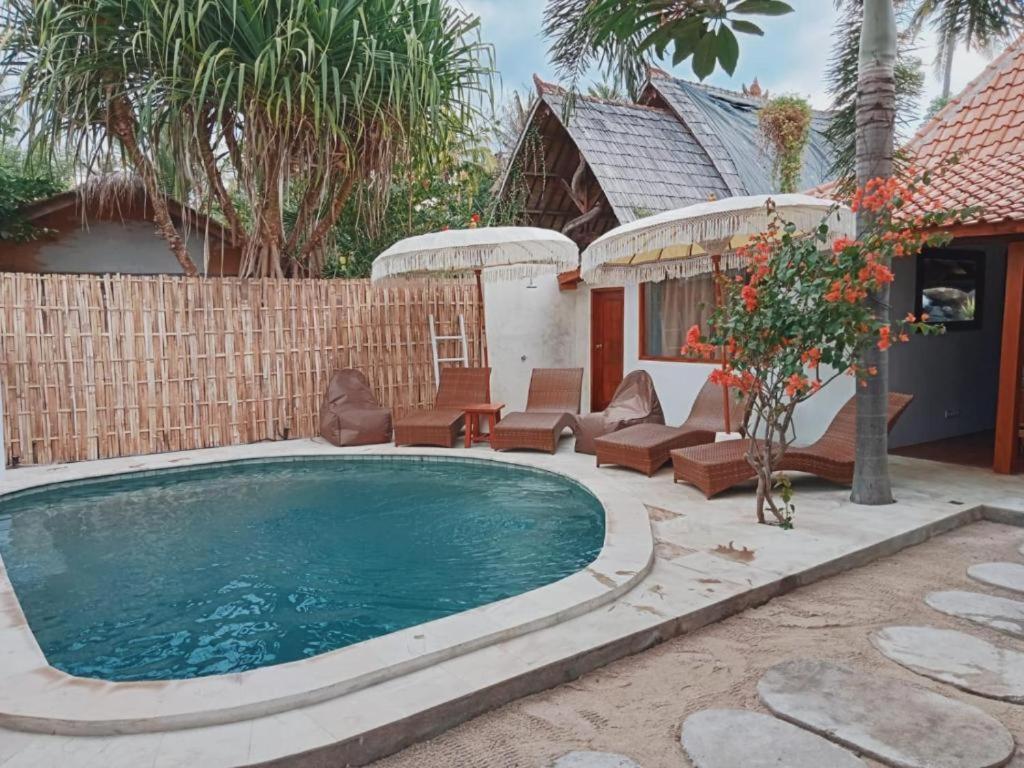 吉利阿尔Ardi Beltza Hotel and Private Pool Villa的后院的游泳池,带椅子和房子