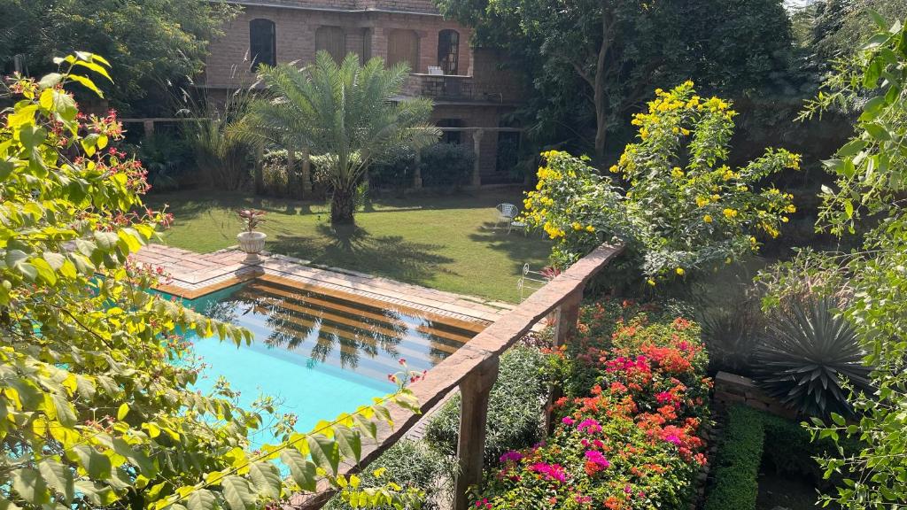 焦特布尔德威巴万 - 传统酒店的一座花园,花园中设有一座桥,位于一座鲜花盛开的游泳池上
