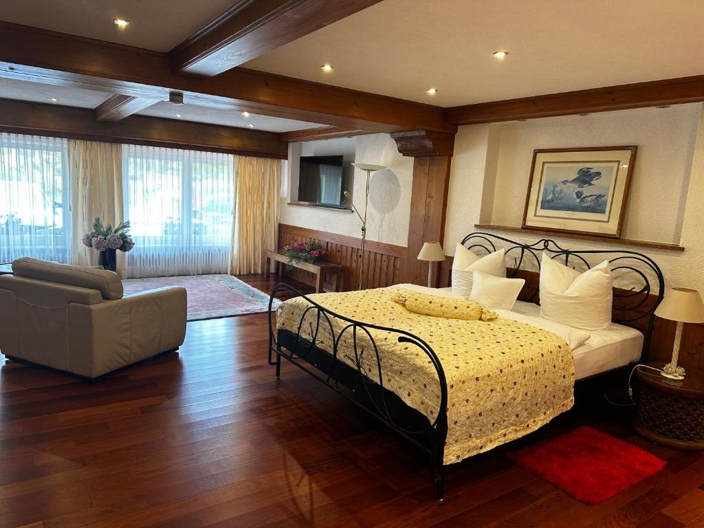 施卢赫湖La Felicita 7的一间卧室配有一张床、一张沙发和一把椅子