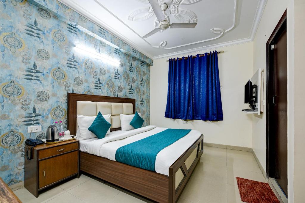 新德里Arkwood Residency B & B At Airport的一间卧室设有一张床和蓝色的墙壁