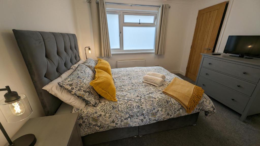 Saint BlazeyChy Lowen Private rooms with kitchen, dining room and garden access close to Eden Project & beaches的卧室配有带枕头的床铺和窗户。