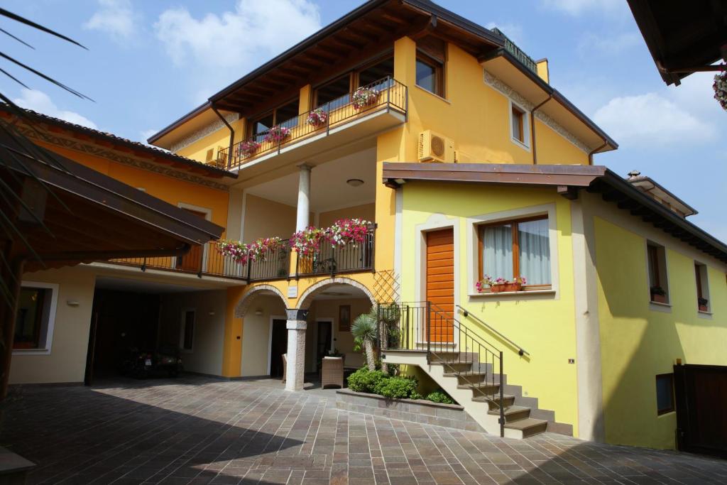 莫尼加伊尔巴隆奈农庄酒店的黄色的房屋设有楼梯和阳台
