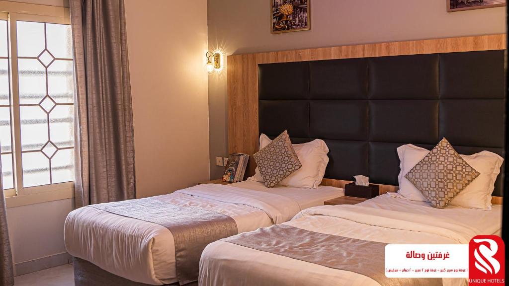 吉达Best Trip Serviced Apartments的酒店客房设有两张床和窗户。