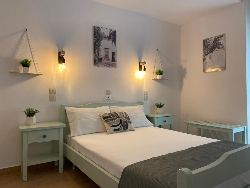 帕蒂迪里奥Ξενοδοχειο Julietta的一间卧室配有一张带两张桌子和两盏灯的床。