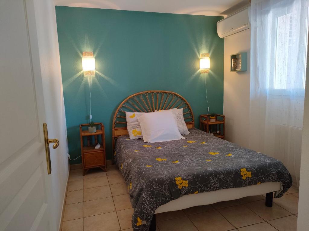 鲁西隆地区卡内appartement en rez-de-chaussée et terrasse sans vis a vis的一间卧室设有一张床和蓝色的墙壁