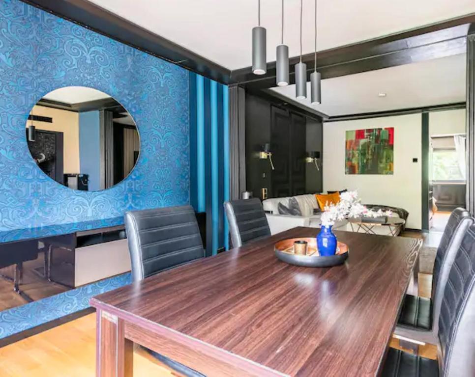柏林Miet-Kamp ruhig, zentral, nahe Messe, ausgefallenes design 2 Schlafzimmer的一间设有木桌和蓝色墙壁的用餐室