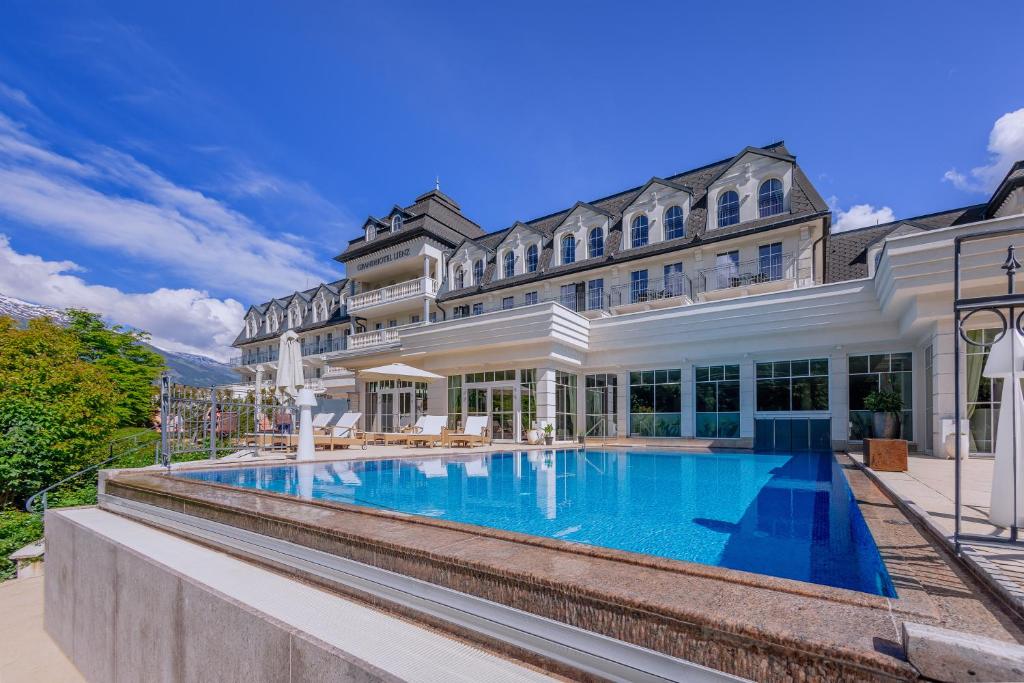 利恩茨Grandhotel Lienz Business-Wellness & Gourmet的享有带游泳池的大厦外部景色