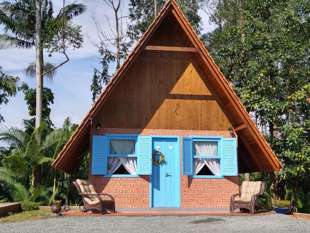 波梅罗迪Chalé Bienen Garten的一座带顶棚和蓝色门的小房子