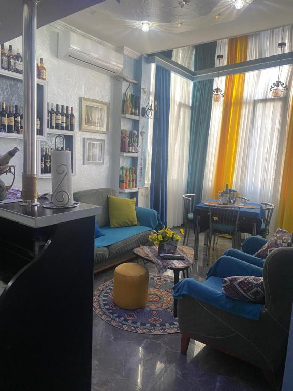 巴统Dea Apartments的客厅配有蓝色的沙发和桌子