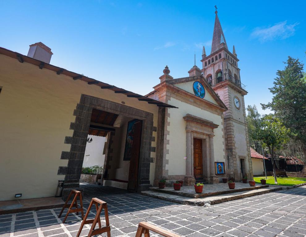 瓦斯卡坎波Hotel Hacienda San Miguel Regla的教堂,塔楼上挂着钟