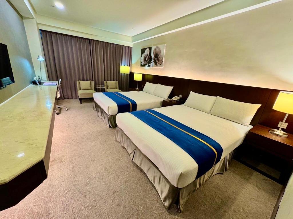 花莲市HiYesHotel勤天商旅-花蓮館的酒店客房配有两张床和一张书桌