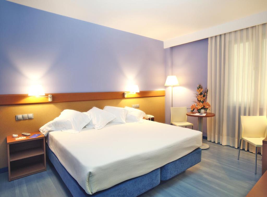 洛格罗尼奥穆列塔酒店的酒店客房带一张大床,带白色床单