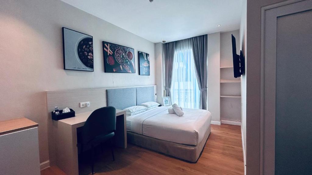 八打灵再也AP Concept Hotel的配有一张床、一张书桌和一扇窗户的酒店客房