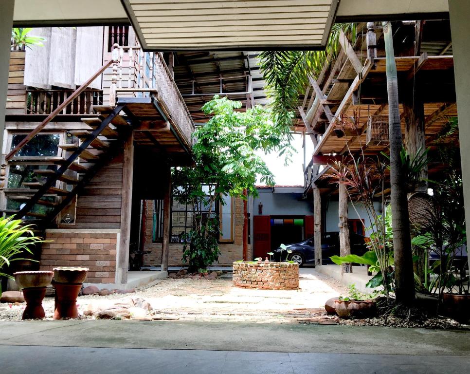 南邦Baan Mali Lampang Homestay的庭院中间的一座带楼梯的建筑