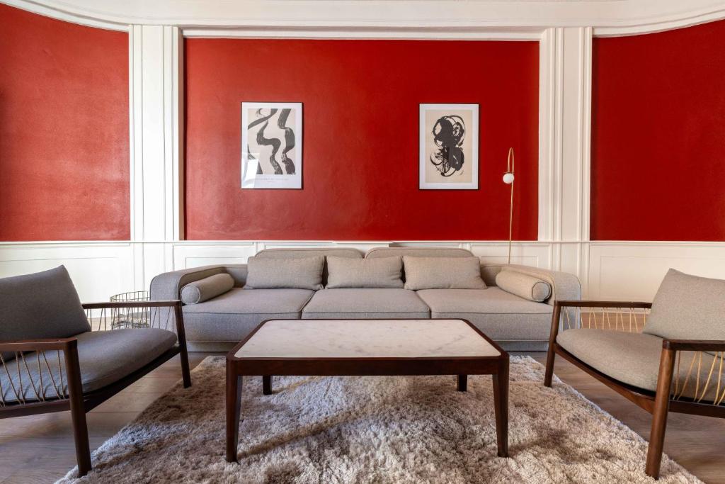 哥本哈根Deluxe Flat at Perfect Location的客厅设有红色的墙壁、沙发和椅子