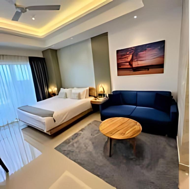 尼甘布Negombo Ocean Breeze Luxury Studio by Serendib Vacation的酒店客房,配有床和蓝色的沙发