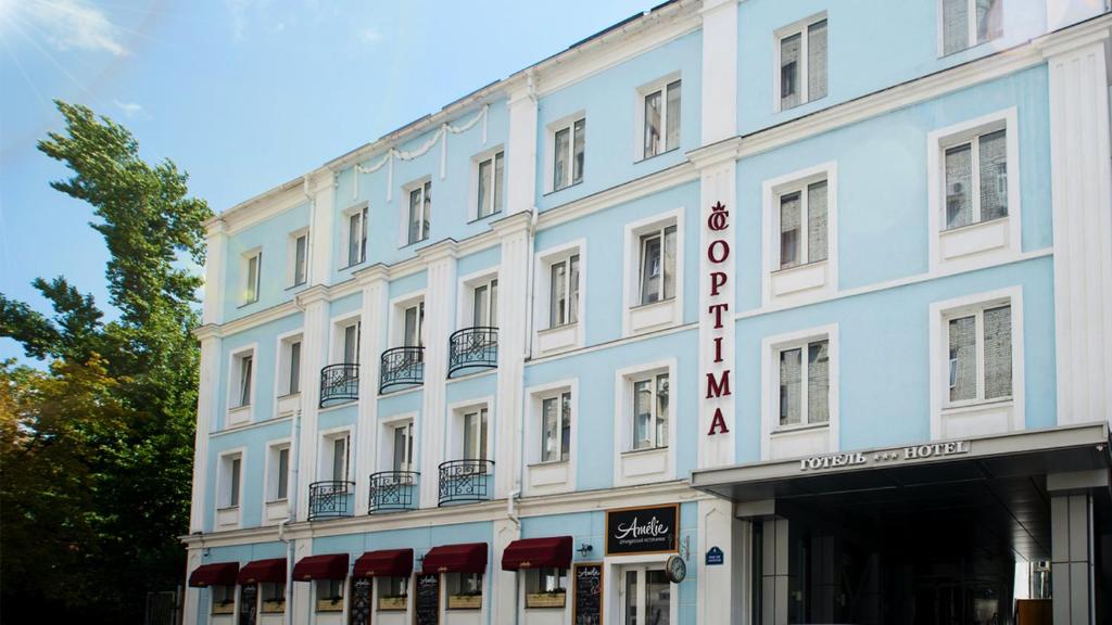 哈尔科夫Optima Collection Kharkiv Hotel的一座白色的大建筑,上面有标志