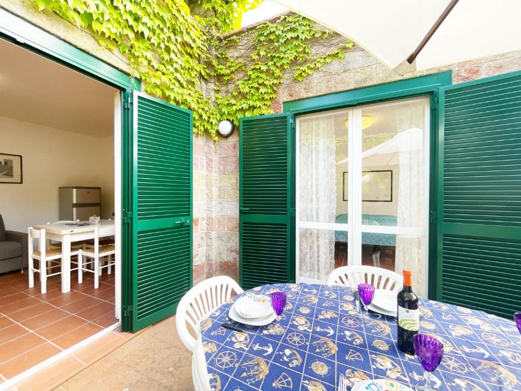 BagnaiaSant'Anna del Volterraio - Strada Maestra (56)的一间设有绿门和桌椅的用餐室