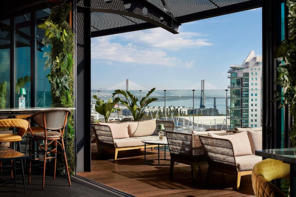里斯本Tivoli Oriente Lisboa Hotel的一个带桌椅的海景庭院