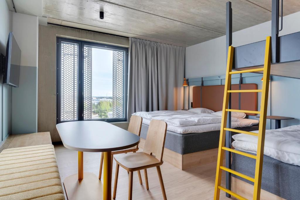 万塔Comfort Hotel Helsinki Airport的一间卧室配有两张双层床、一张桌子和一张桌子