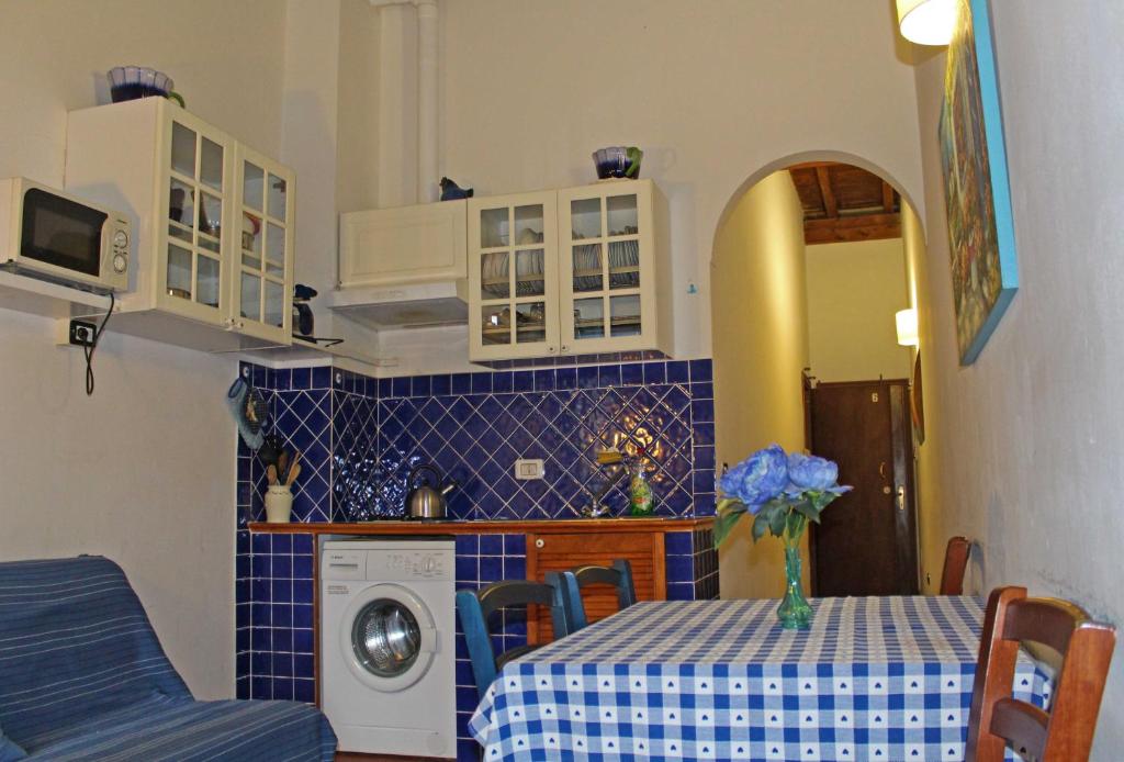 佛罗伦萨马克斯公寓酒店的厨房配有桌子和洗衣机。