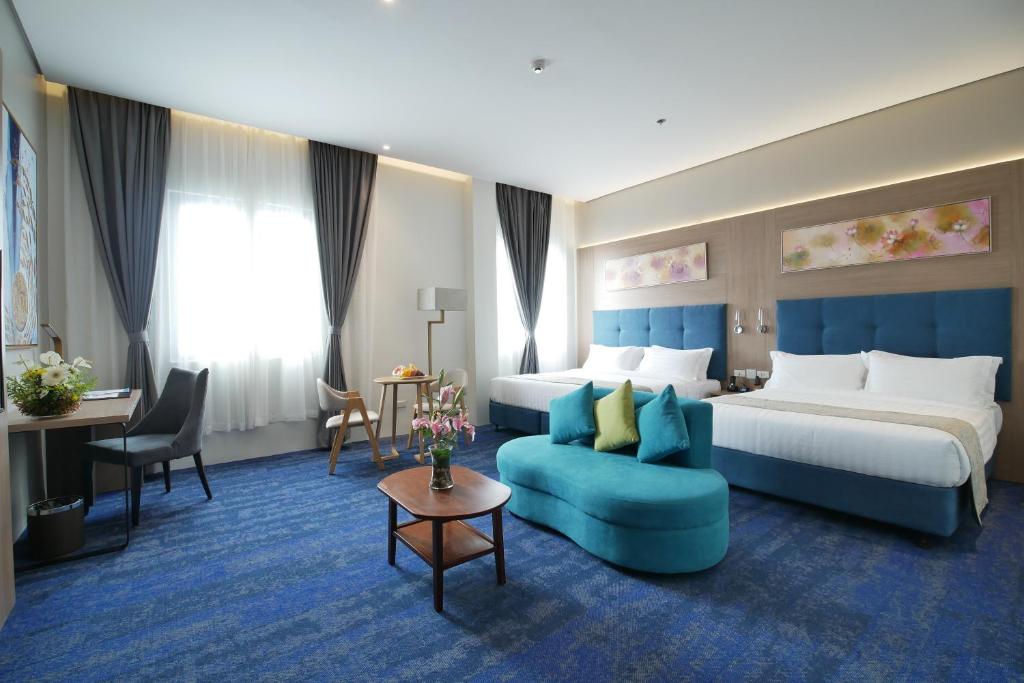 达沃市Blue Lotus Hotel的酒店客房,设有两张床和一张蓝色的沙发