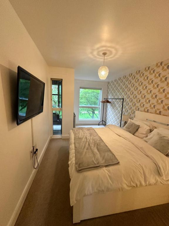 伦敦Cosy 1 Bed Apartment near Excel London的一间卧室配有一张床和一台平面电视