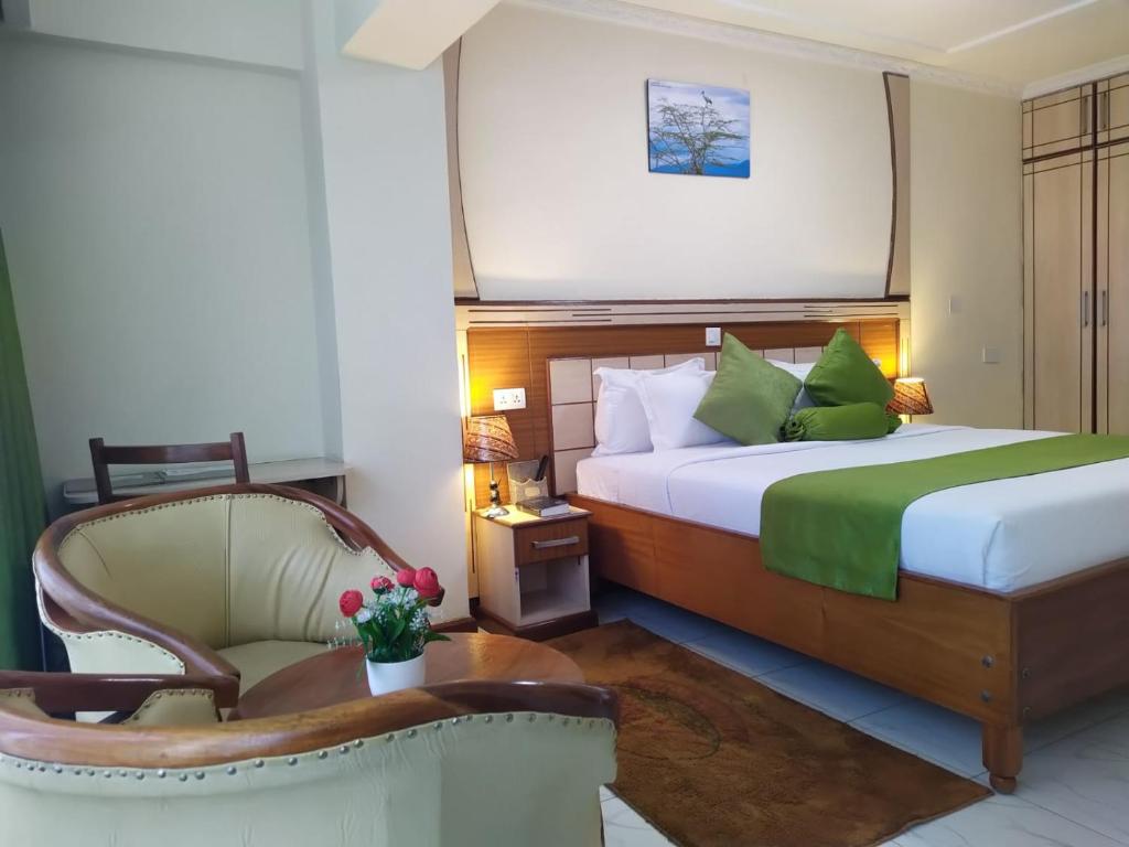 纳库鲁Empolos Hotel Nakuru的配有一张床和一把椅子的酒店客房