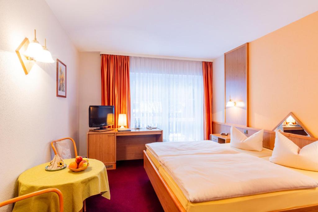 永斯多夫Hotel Gondelfahrt的酒店客房设有两张床和电视。