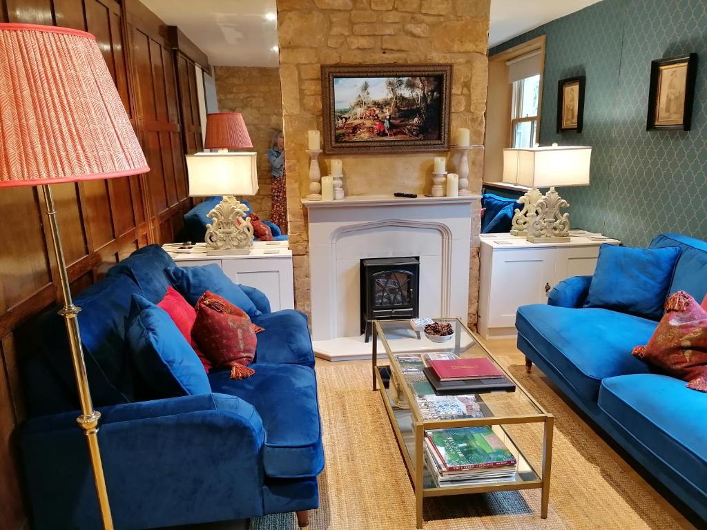 奇平卡姆登Merriman Cottage的客厅配有2张蓝色沙发和壁炉