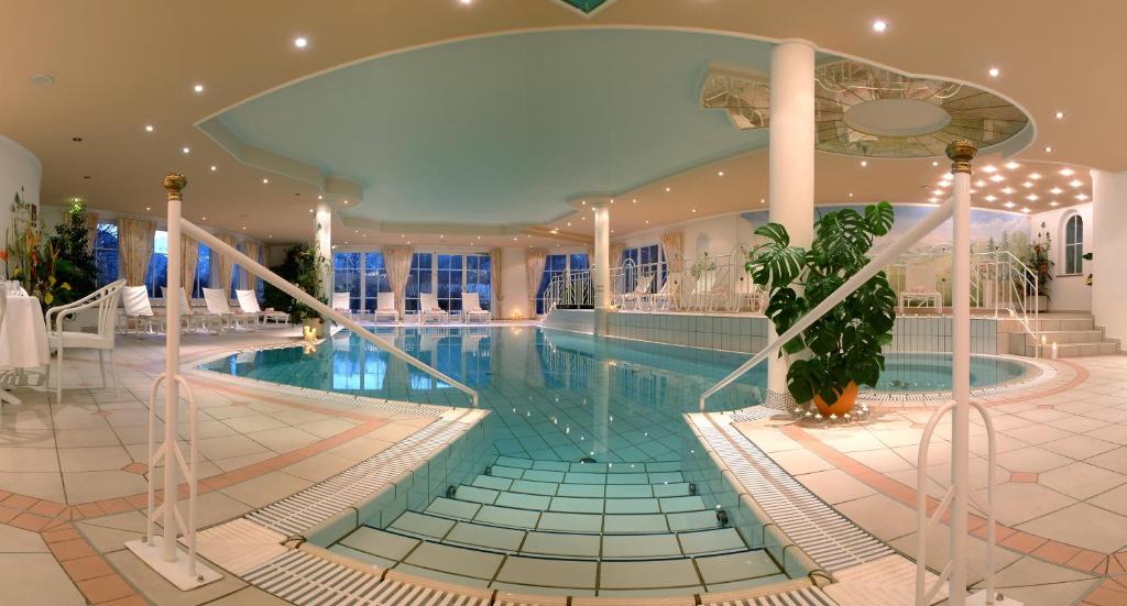 巴特霍夫加施泰因Hotel Zum Stern的大型建筑内的大型游泳池,设有游泳池