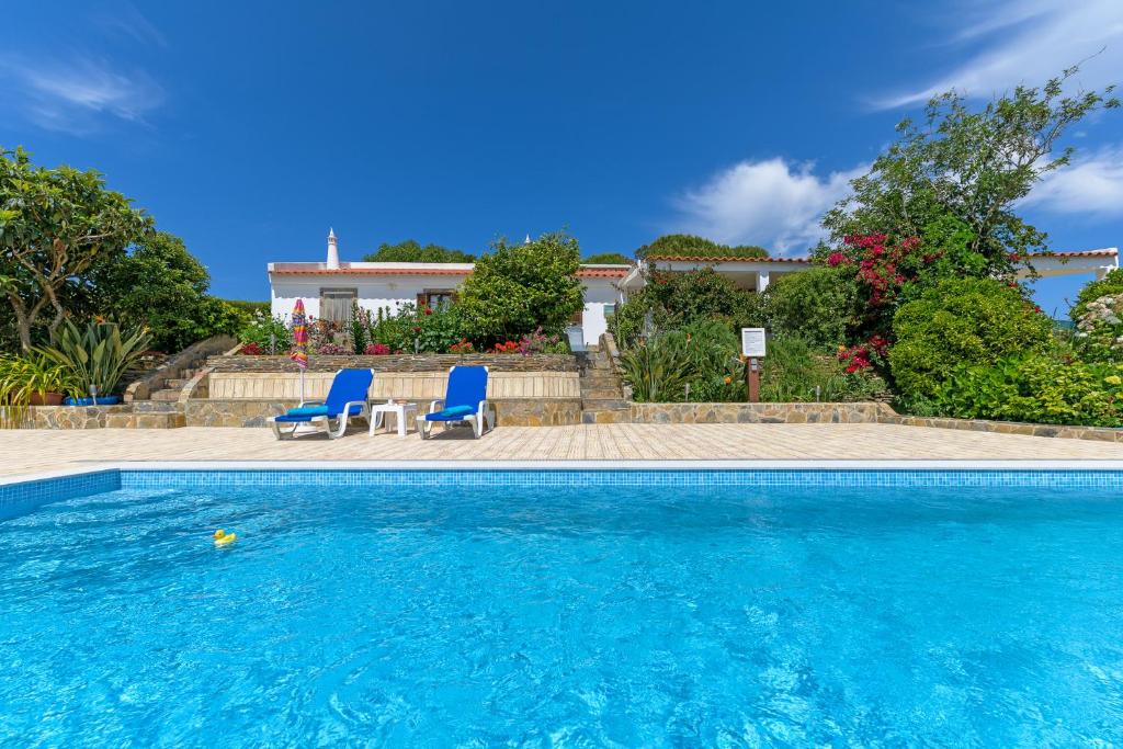 阿尔热祖尔Bela casa na Costa Vicentina的一个带2把蓝色椅子的游泳池