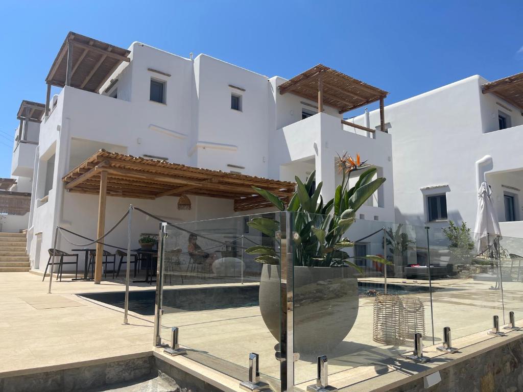 斯希努萨岛Sohoros Luxury Suites的前面有盆栽的白色建筑