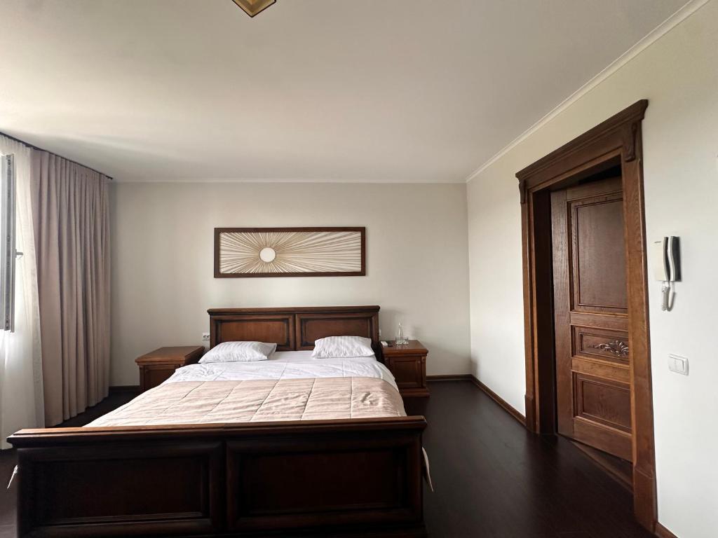 BrzezhanyЕдем的一间卧室配有一张大床和木制床头板