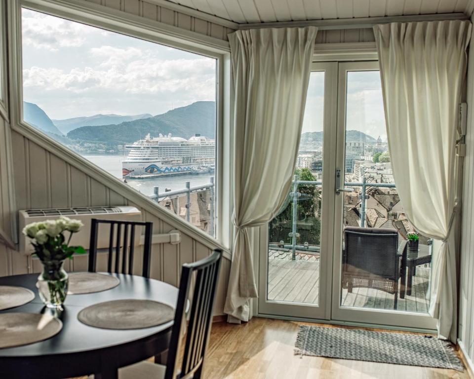 奥勒松Panorama Apartment Ålesund的一间带游轮景阳台的用餐室