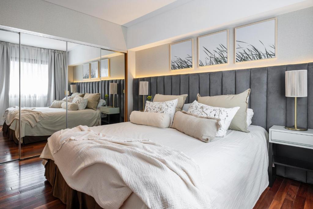 布宜诺斯艾利斯安再尼卡塔套房酒店 的卧室配有一张白色大床和镜子