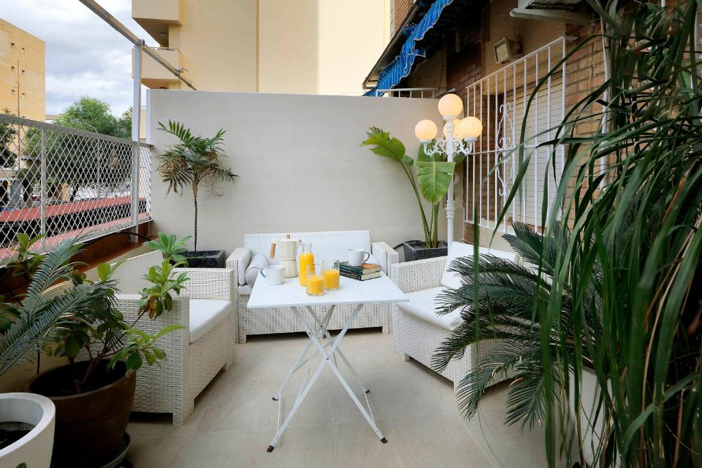 塞维利亚Apartamento Jardín Cerca del Centro的阳台配有桌椅和植物