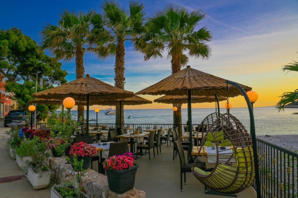 赫瓦尔弗图纳酒店的海滩上的餐厅,配有桌子和遮阳伞
