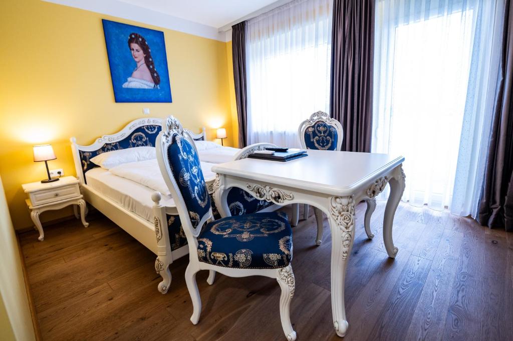 莱布尼茨Hotel Vulkan Residenz - Self-Check-in的卧室配有一张床和一张桌子及椅子