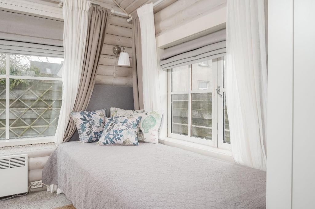 派尔努Guesthouse Delisa的卧室配有带枕头的床铺和窗户。