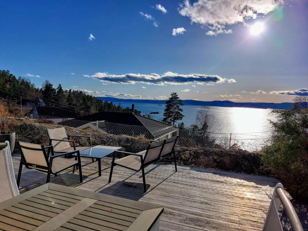 NesoddtangenOslo Fjord views with your own private beach hut at Flaskebekk的湖景甲板配有桌椅