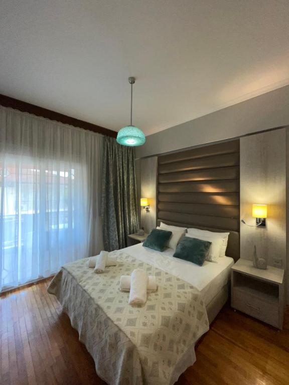 帕拉利亚狄奥尼索Maria Apartments的一间卧室设有一张大床和一个大窗户
