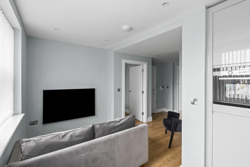 切姆Luxurious One Bedroom Apartment in Bond Street的客厅配有沙发和墙上的电视