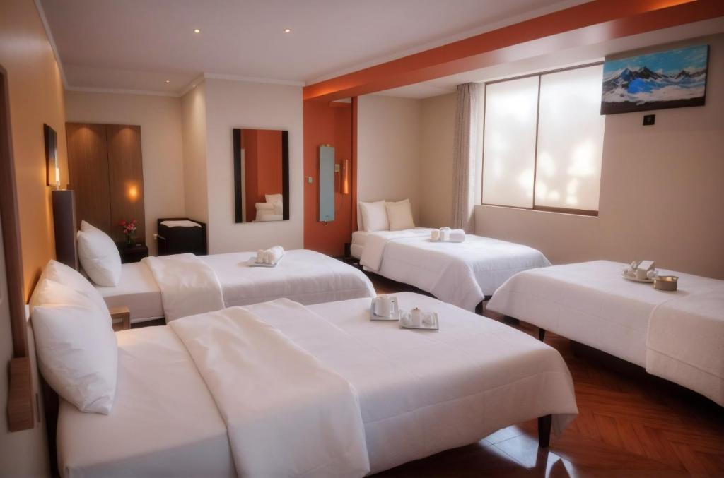 卡哈马卡Hotel Balcones Plaza的酒店客房设有三张床和窗户。