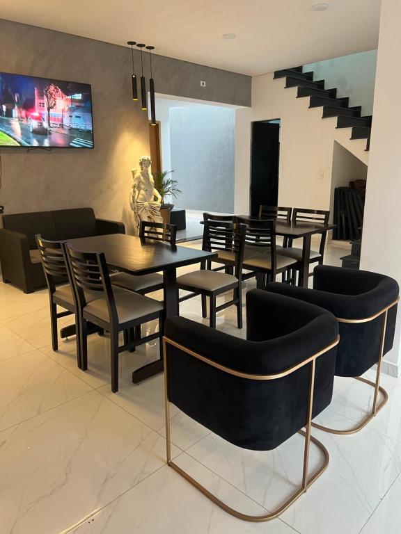 阿帕雷西达Hotel Pousada Colliseu的用餐室配有桌椅和电视