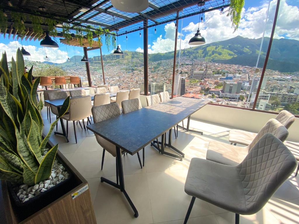 基多Hostal La Terraza的一间设有桌椅并享有美景的餐厅