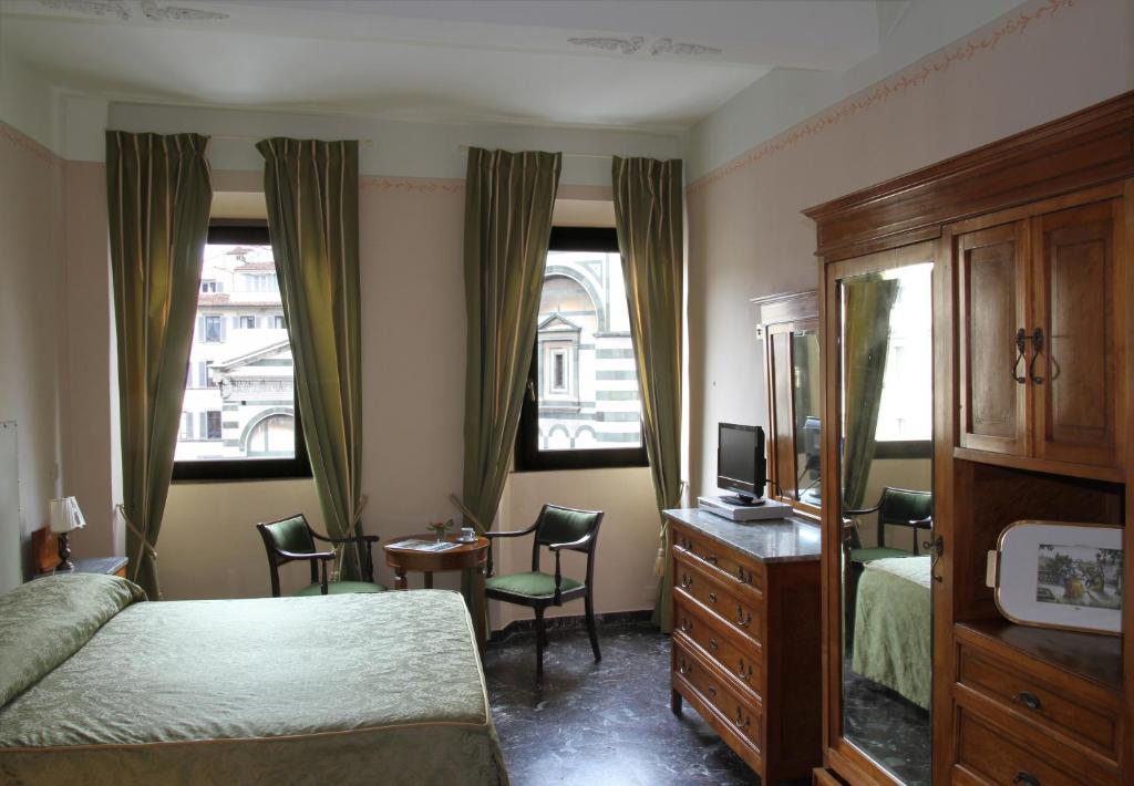 佛罗伦萨佛罗伦萨景致食宿酒店的一间卧室配有一张床、一个梳妆台和两个窗户。
