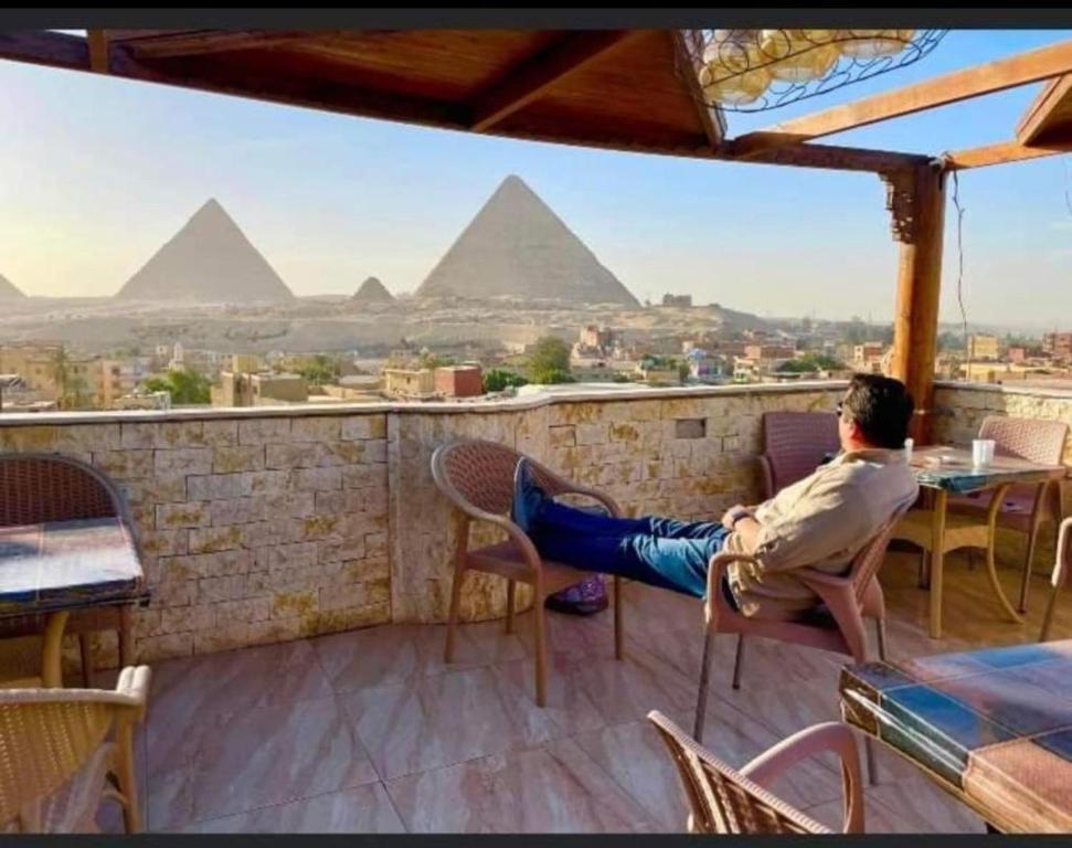 开罗City pyramids inn的坐在金字塔上阳台的人