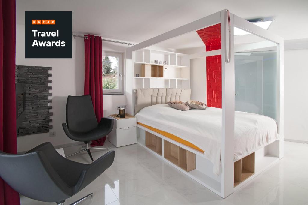 韦尼格罗德Designpension Idyll Nr2 Hotel Garni的白色卧室配有床和椅子